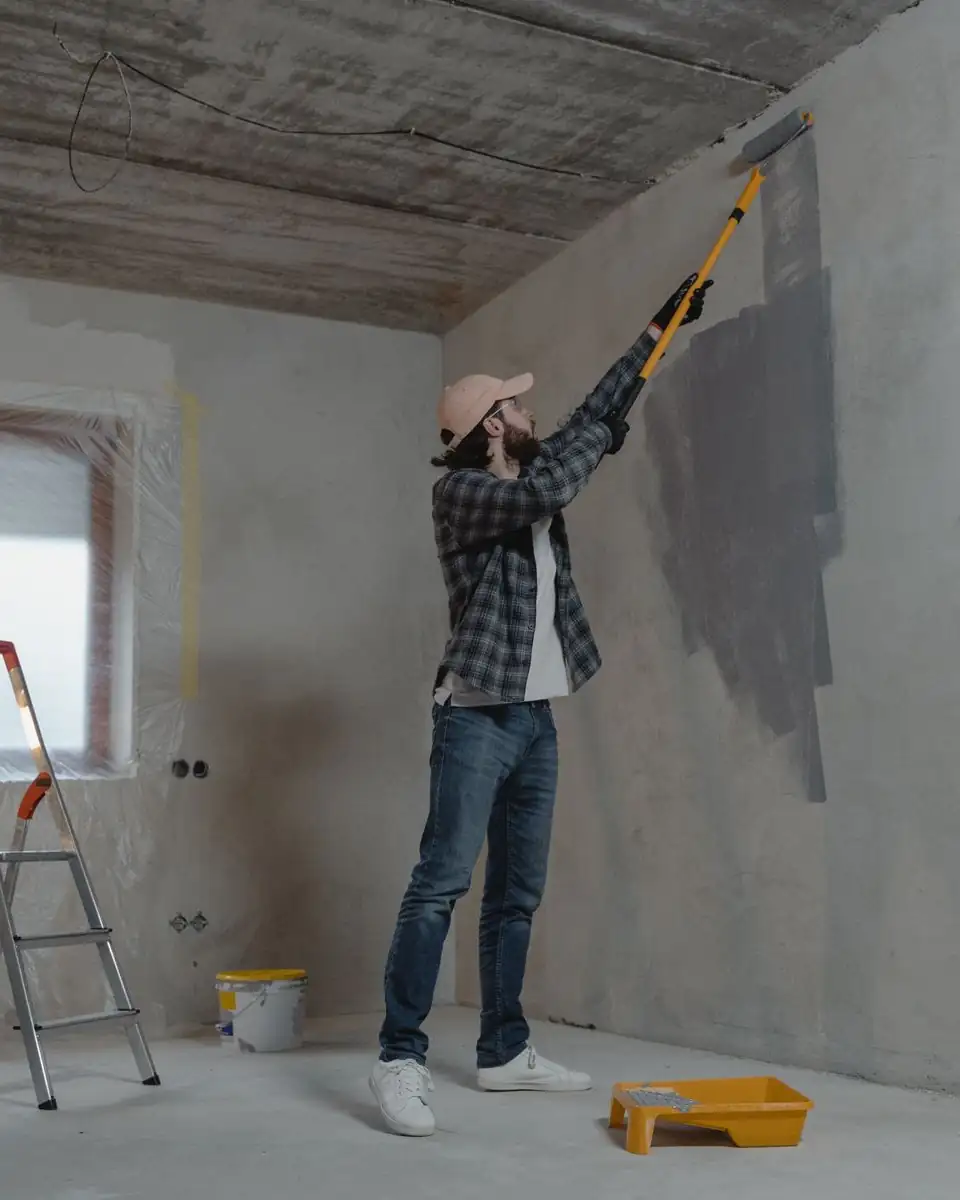 Painter rolling paint onto an interior wall